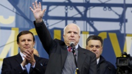 U.S. Senator John McCain (C) waves to pro-European intergration protesters during a mass rally at Independence Square in Kyiv December 15, 2013. Flanking hi, are U.S. Senator Chris Murphy (L) and one of Ukraine's opposition leaders, Oleh Tyahnybok.