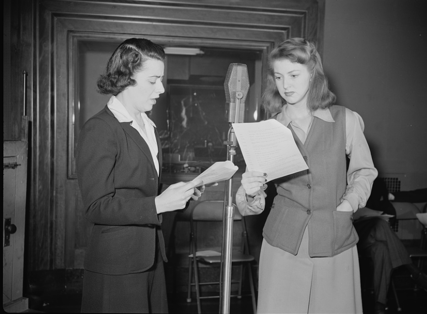"You Can't Do Business With Hitler." Ilona Killian (left) and Virginia Moore are rehearsing for "You Can't Do Business With Hitler" radio show, written and produced by the radio section of the Office of War Information (OWI) which also produced programs for the Voice of America (VOA) overseas audiences. This series of programs was broadcast domestically in the United States by 790 stations throughout the country. 