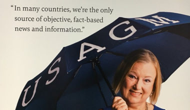 VOA Director Amanda Bennett holding a USAGM umbrella for a publicity photo. In 2018, the U.S. Broadcasting Board of Governors (BBG), the federal agency in charge of VOA, changed its name to the U.S. Agency for Global Media (USAGM). President Biden nominated Bennett to be USAGM CEO pending confirmation by the U.S. Senate.