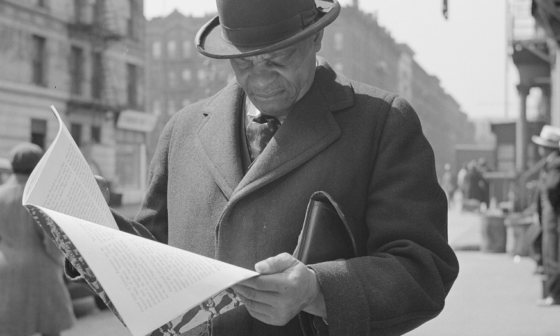Photograph: New York, New York. A. Marcus Garveyite reading the OWI (Office of War Information) publication Negroes and the War, April 1943. Library of Congress Prints and Photographs Division, Washington, D.C. 20540, USA. OWI was the Executive Branch agency under the control of the White House. Its Overseas Division produced World War II shortwave radio broadcasts, which were later named the Voice of America (VOA).